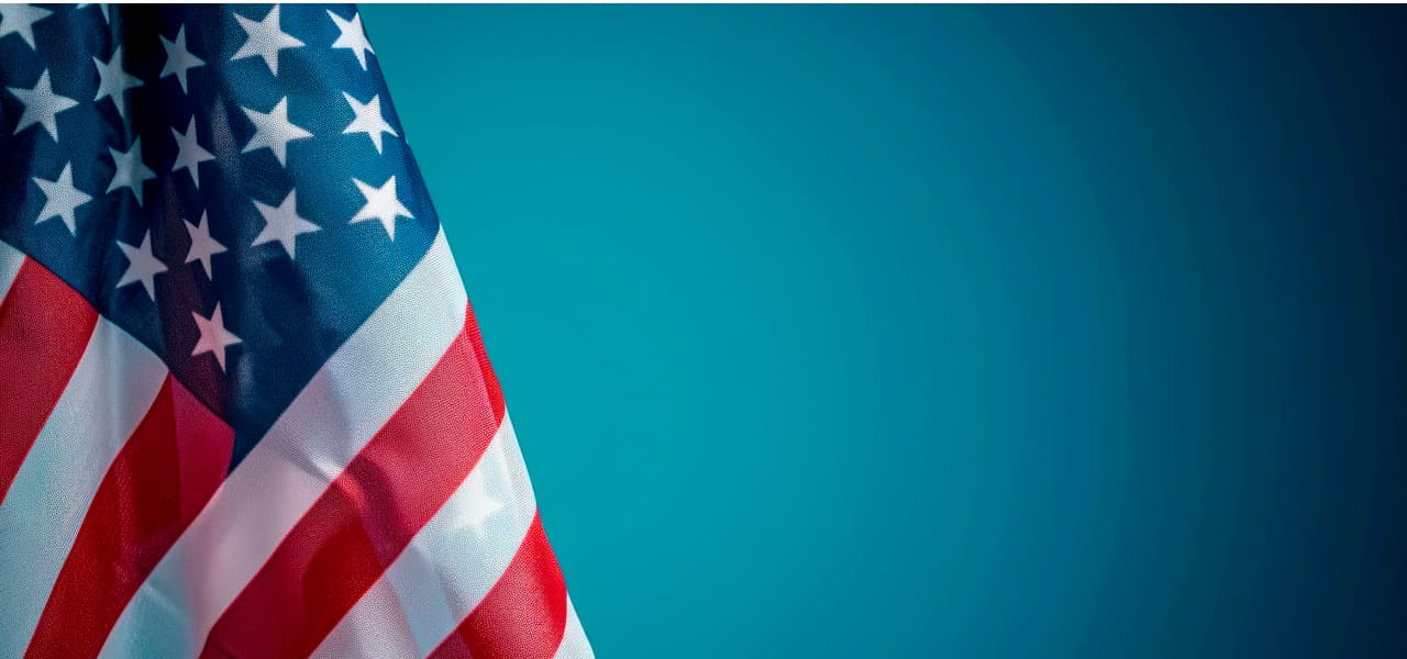 A Amerika 1 Header (jpg) | Motiv ©Hunman - stock.adobe.com | © stock.adobe.com, September 2024 Amerikanische Flagge vor blauem Hintergrund. | Motiv ©Hunman - stock.adobe.com | © stock.adobe.com, September 2024